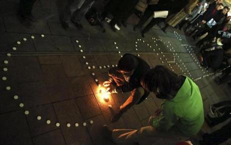 People light candles to form the word ?Charlie? in front of the European Parliament.
